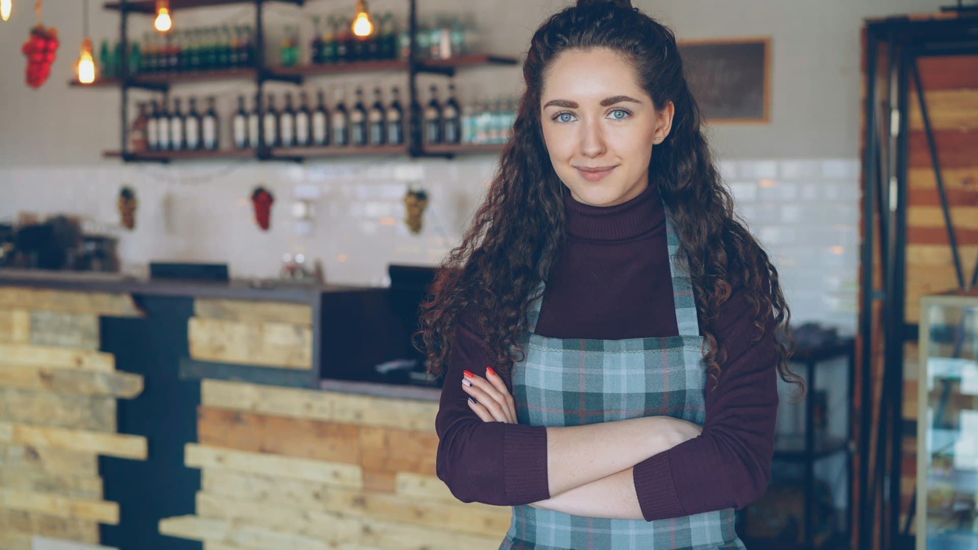 A café owner standing proudly in her coffee shop